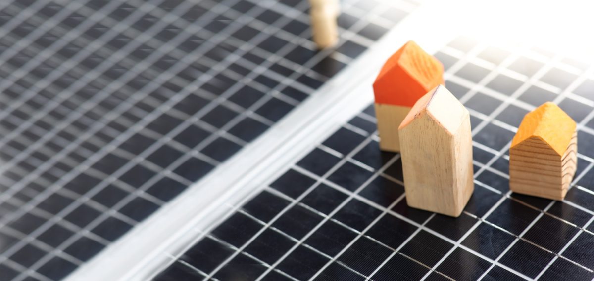 Des maisons en bois sont posées sur un fond conçu en panneaux solaires